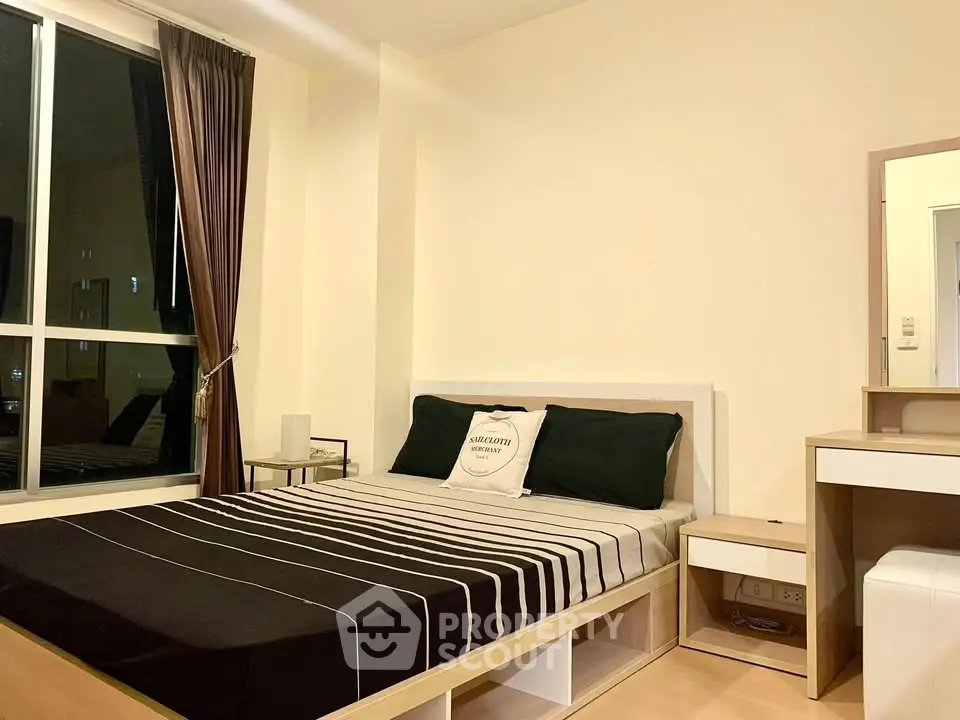 Modern bedroom with stylish decor and large window for natural light.