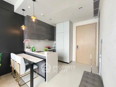 Modern kitchen with sleek design, featuring a breakfast bar and stylish lighting.