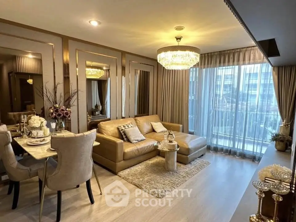 Luxurious living room with elegant decor, chandelier, and large windows in a modern apartment.