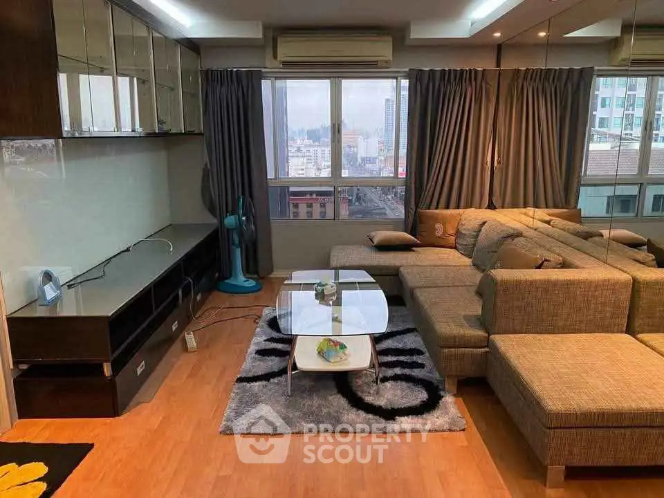 Spacious living room with modern sectional sofa and city view, perfect for urban living.