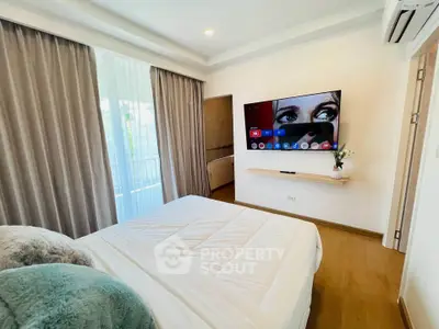 Modern bedroom with wall-mounted TV and elegant decor in a stylish apartment.