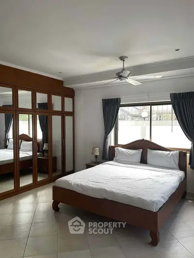 Spacious bedroom with large mirrored wardrobe and elegant decor