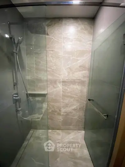 Modern bathroom with sleek glass shower enclosure and elegant tile design.