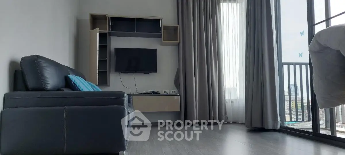 Modern living room with sleek sofa and balcony view in high-rise apartment