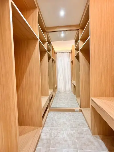 Spacious walk-in closet with wooden shelves and bright lighting