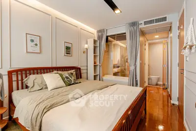 Cozy bedroom with ensuite bathroom featuring modern decor and wooden flooring.
