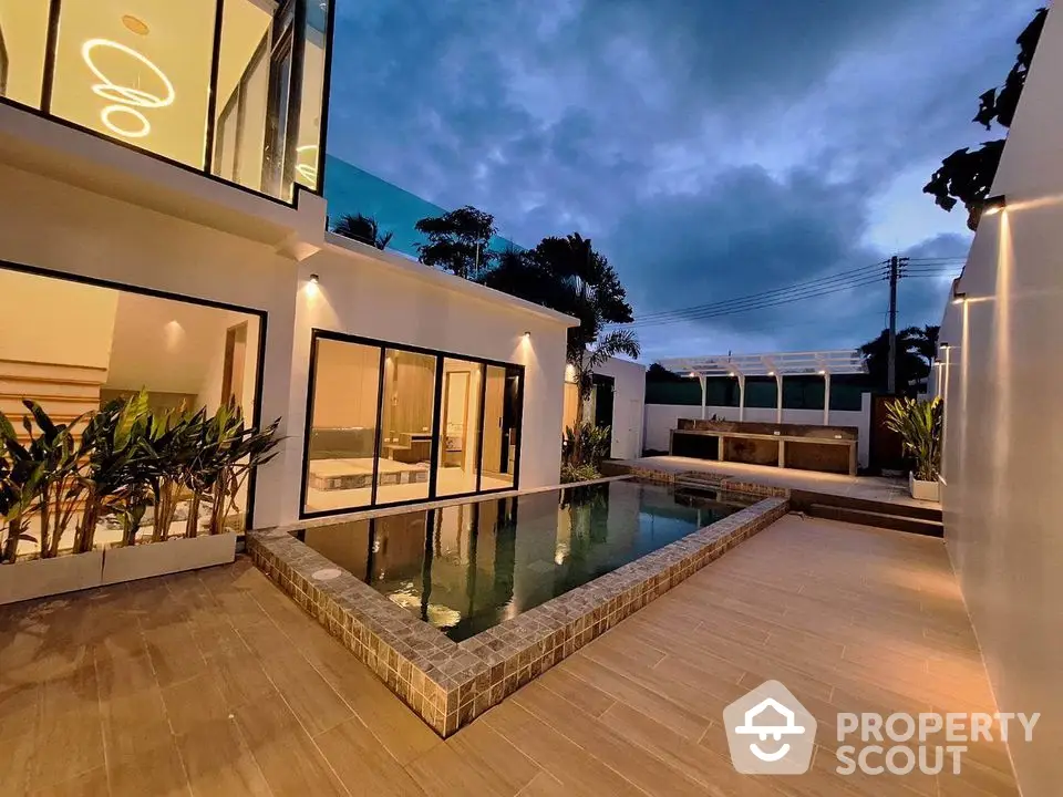 Luxurious modern home with private pool and elegant outdoor lighting at dusk.