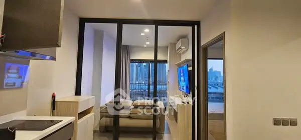 Modern apartment interior with sleek kitchen and cozy living area overlooking cityscape.