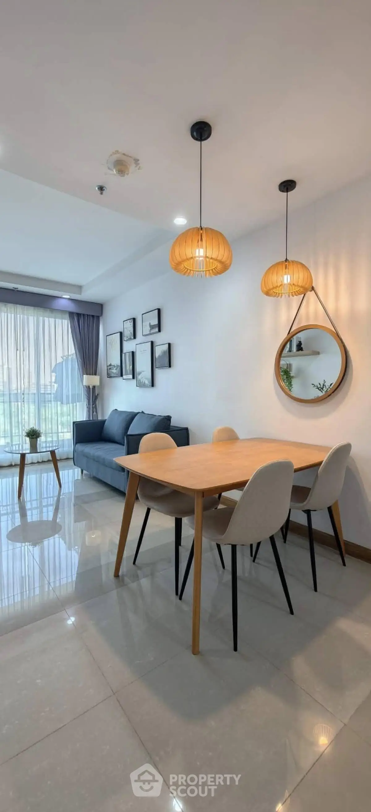 Modern living room with stylish dining area, elegant lighting, and cozy seating in a contemporary apartment.