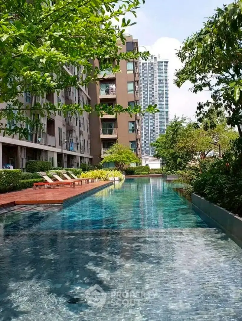 Luxurious residential pool area with lush greenery and modern architecture.
