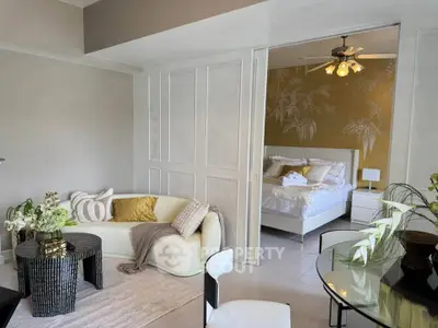 Stylish open-plan living room with cozy bedroom view, featuring elegant decor and modern furnishings.