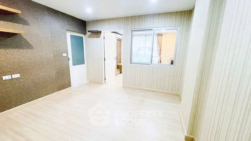 Spacious empty room with wooden flooring and modern design, perfect for customization.