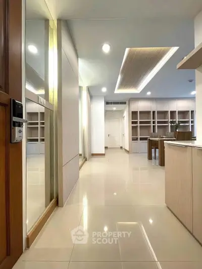 Spacious modern apartment interior with sleek design and ample natural light, featuring built-in shelves and glossy floors.