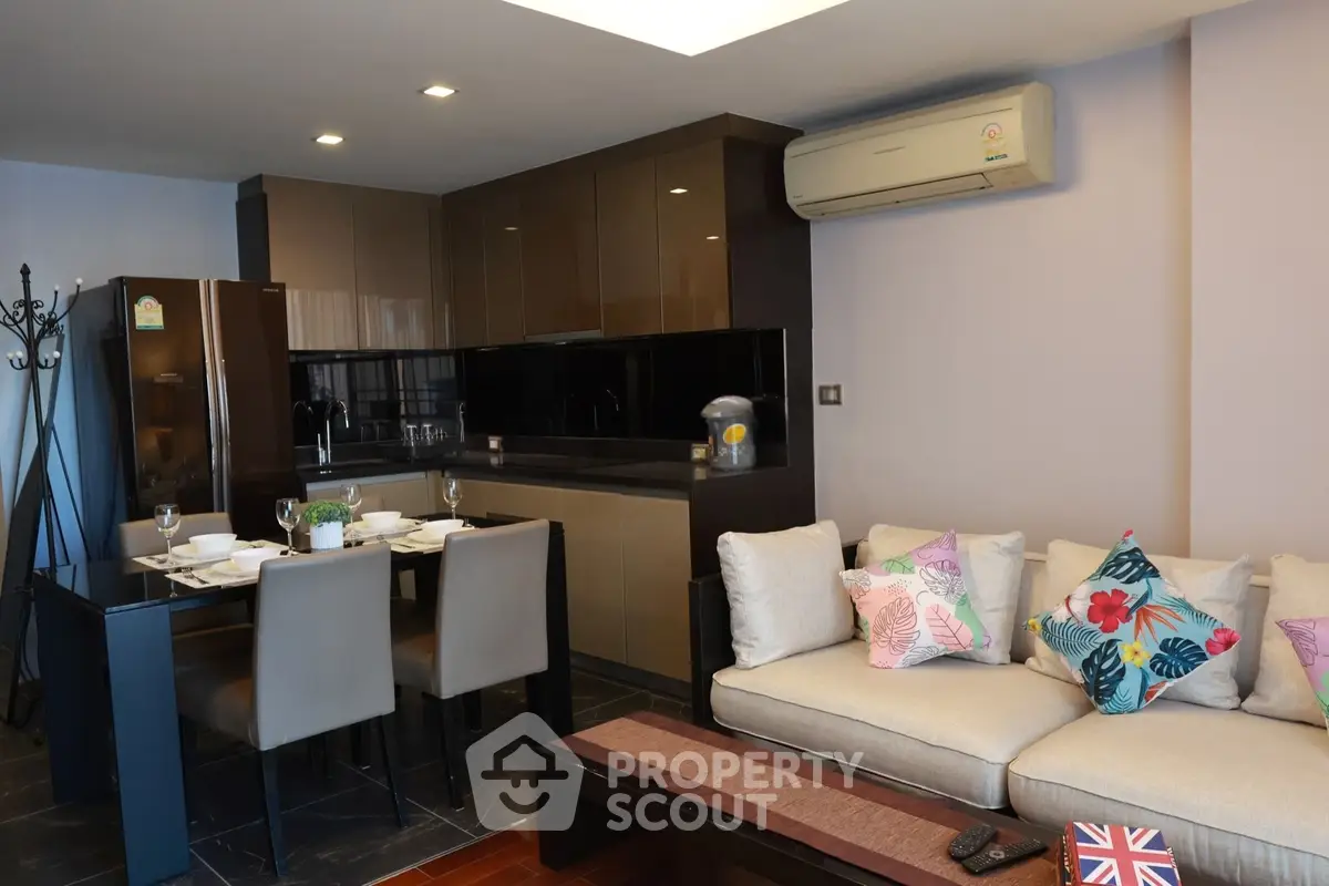 Modern open-layout kitchen and living room with stylish decor and dining area.