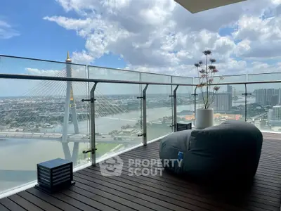Stunning balcony with panoramic river view and modern seating, perfect for relaxation and enjoying cityscape.