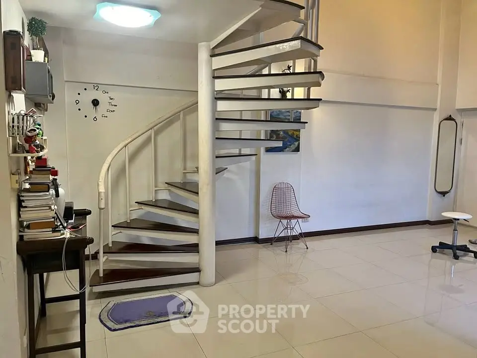 Spacious interior with spiral staircase and modern decor, ideal for stylish living.