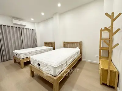 Spacious bedroom with twin beds and modern decor in a stylish apartment.