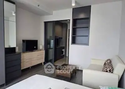 Modern living room with sleek furniture and open kitchen layout in a stylish apartment.