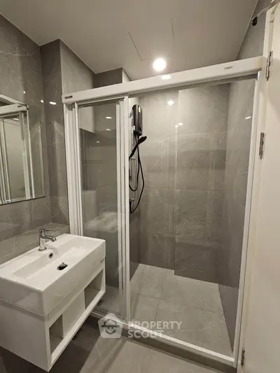 Modern bathroom with sleek shower and elegant sink in luxury apartment.