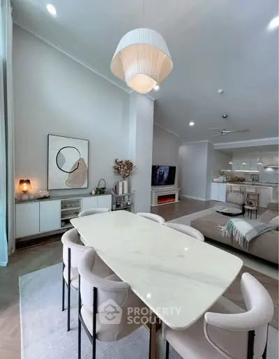Elegant open-plan living and dining area with modern decor and stylish lighting.