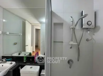Modern bathroom with shower, sink, and toilet in a sleek design.