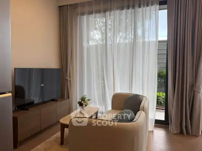 Cozy living room with modern decor and large window overlooking a garden.