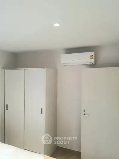 Modern bedroom with air conditioning and sleek wardrobe design.