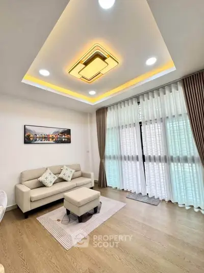 Modern living room with stylish ceiling lights and large windows with curtains.