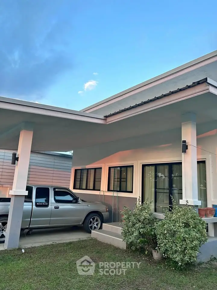 Modern single-story home with carport and lush greenery