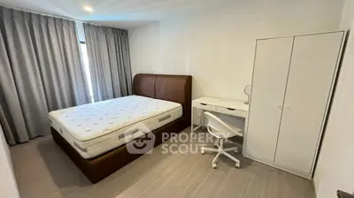 Modern bedroom with minimalist design featuring a comfortable bed and study desk.