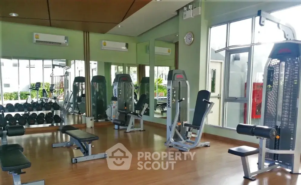 Modern gym with state-of-the-art equipment and mirrored walls in a residential building.