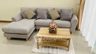 Cozy living room with modern gray sectional sofa and wooden coffee table, perfect for relaxation.
