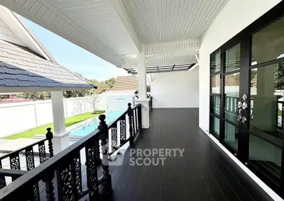 Spacious balcony with elegant railing overlooking a pool in a modern home.