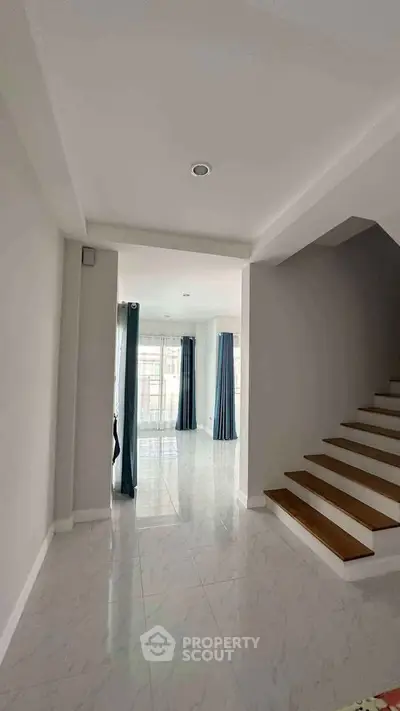 Spacious modern interior with elegant staircase and natural light