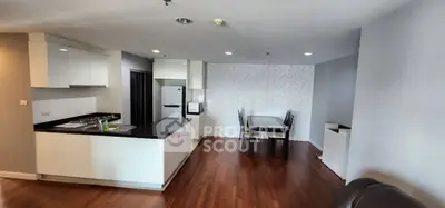 Modern open-plan kitchen and dining area with sleek design and wooden flooring.