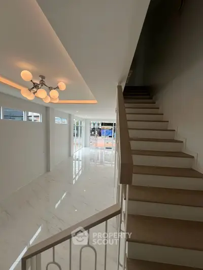 Elegant modern interior with staircase and stylish lighting in a spacious living area.