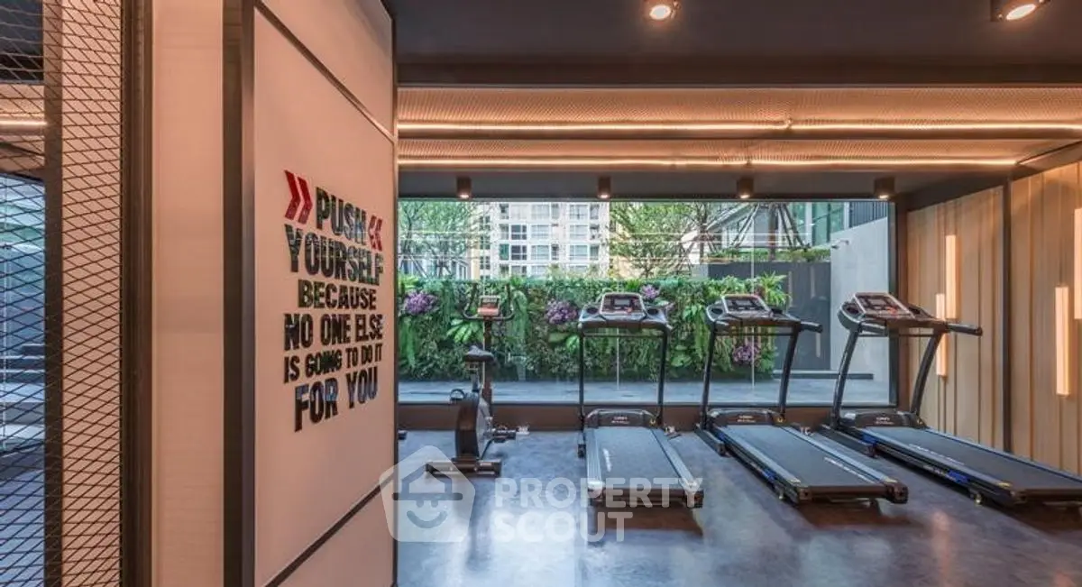 Modern gym with treadmills and motivational quote in luxury residential building.
