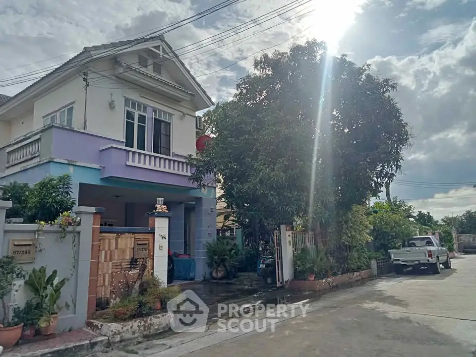 Charming two-story house with lush garden and driveway in a serene neighborhood.