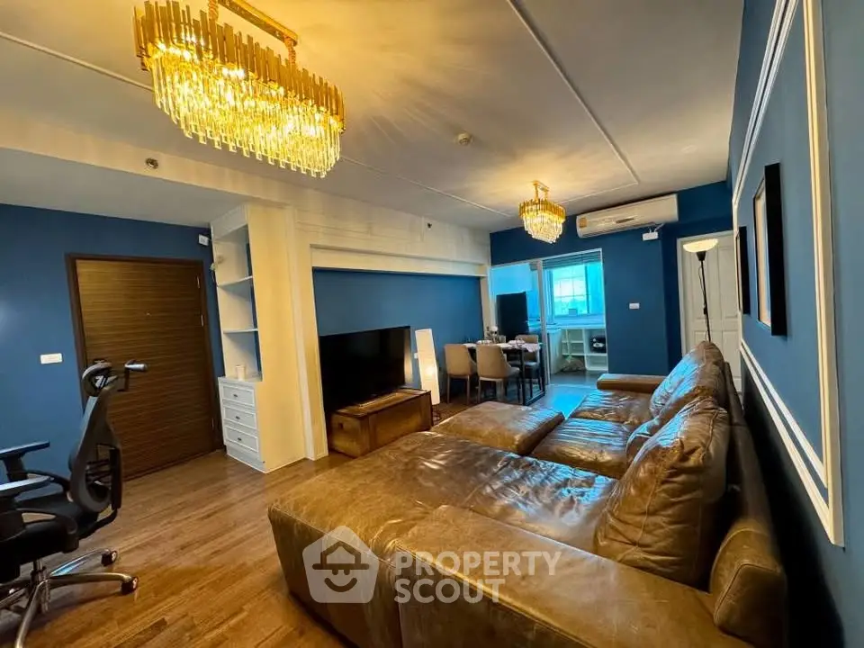 Luxurious living room with elegant chandeliers and plush leather seating