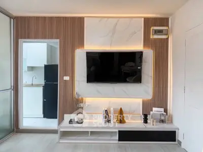 Modern living room with stylish TV wall and open kitchen view