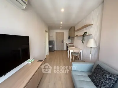 Modern living room with open kitchen, stylish decor, and cozy seating area in a contemporary apartment.