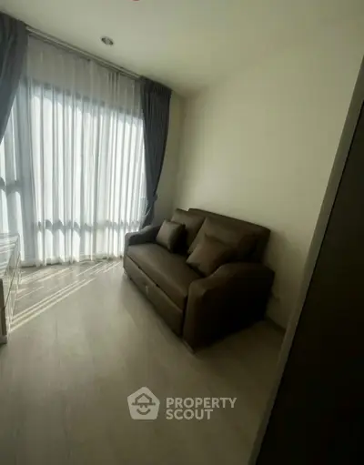 Cozy living room with natural light and modern sofa in a stylish apartment.