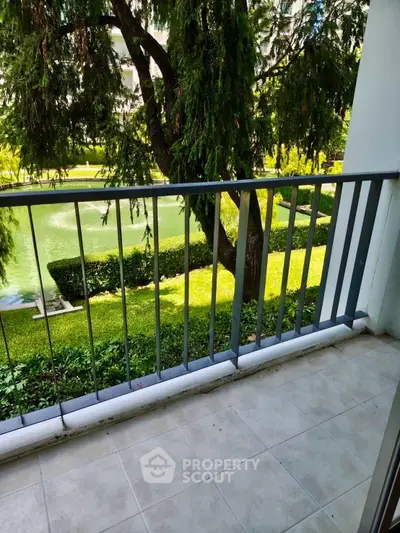 Charming balcony with lush garden view in modern apartment complex.