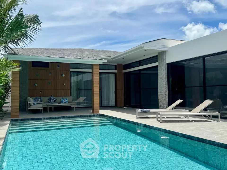 Luxurious modern villa with private pool and stylish outdoor seating under a clear blue sky.