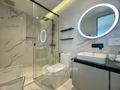 Luxurious modern bathroom with elegant marble tiles and illuminated mirror