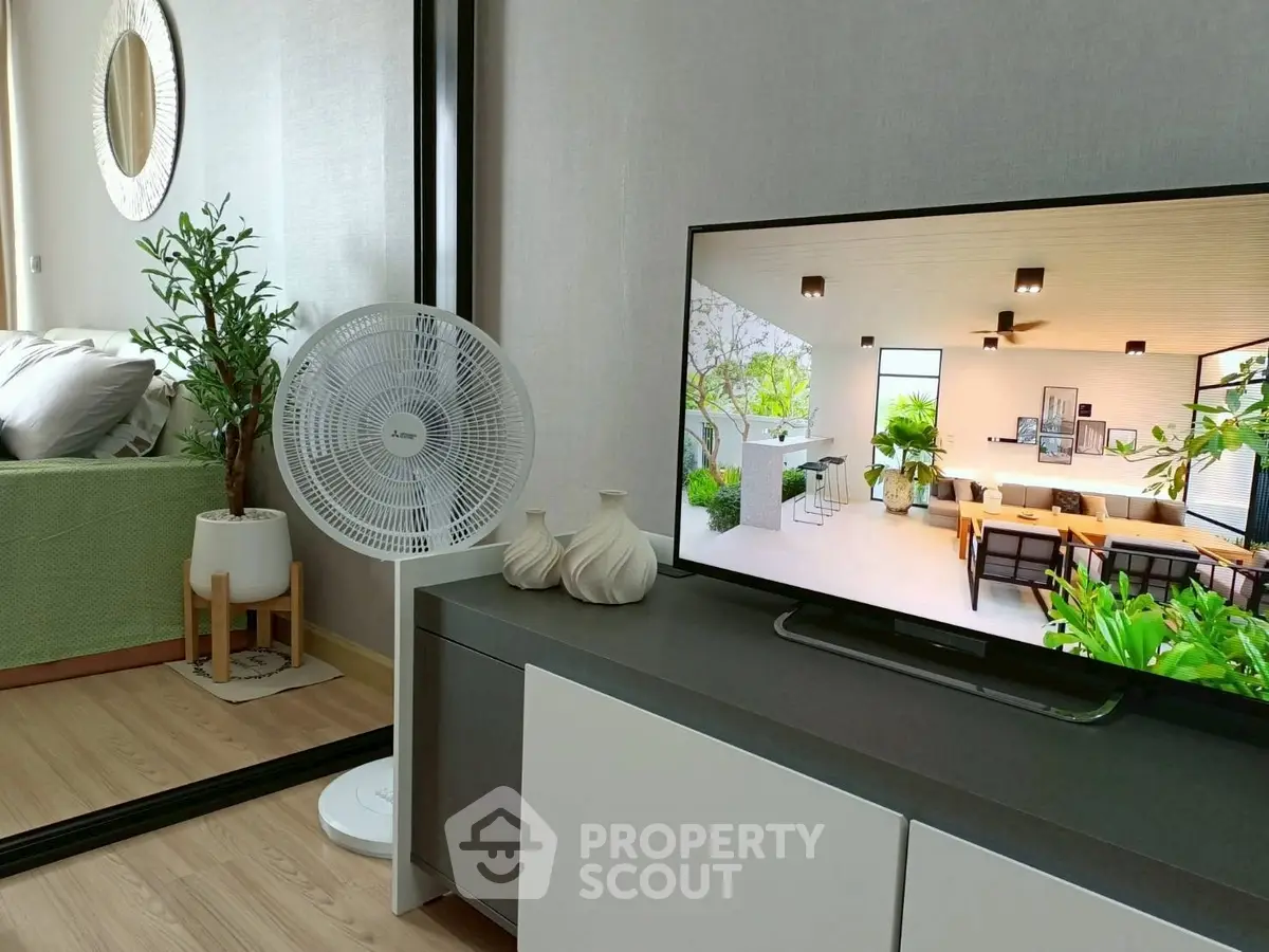 Modern living room with sleek TV stand, stylish decor, and cozy bedroom view.