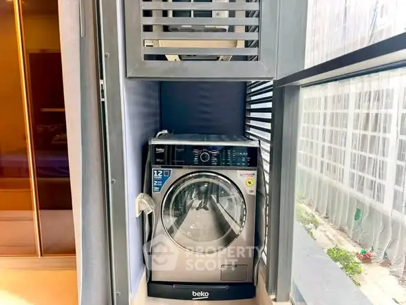 Modern laundry area with high-efficiency washing machine in sleek apartment setting.