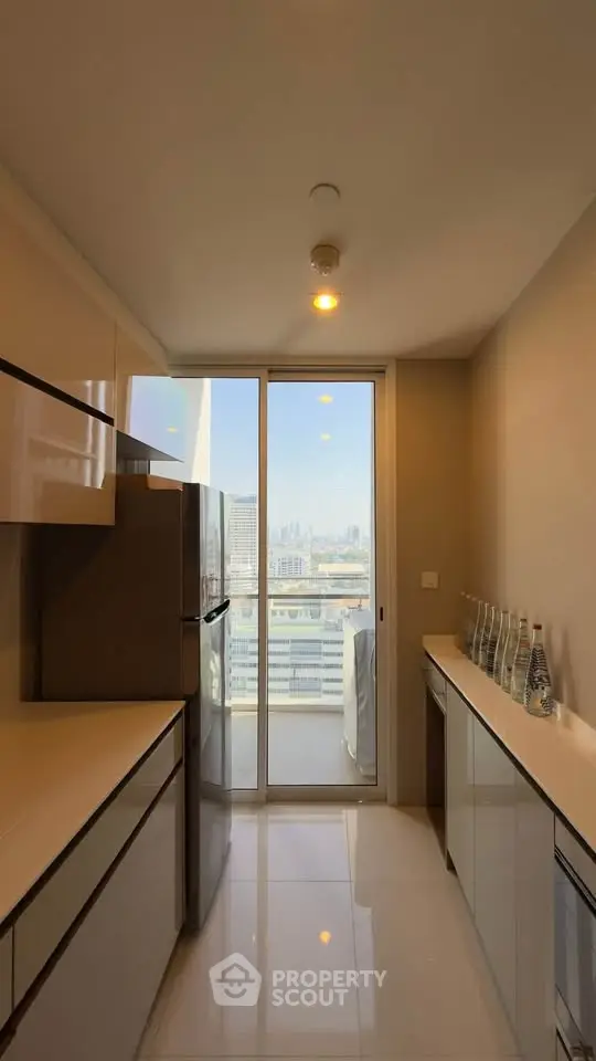 Modern kitchen with sleek cabinetry and city view from balcony