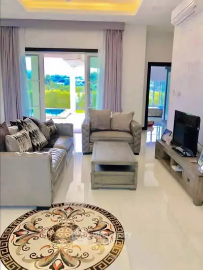 Luxurious living room with elegant decor and pool view, perfect for relaxation and entertainment.