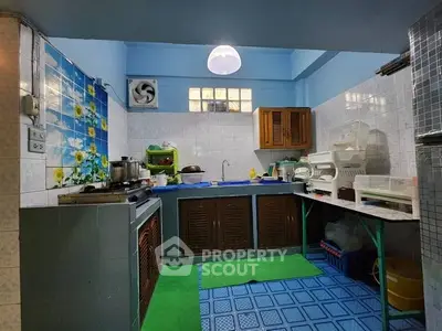 Charming kitchen with vibrant blue tiles and ample storage, featuring a cozy closed layout perfect for culinary adventures.